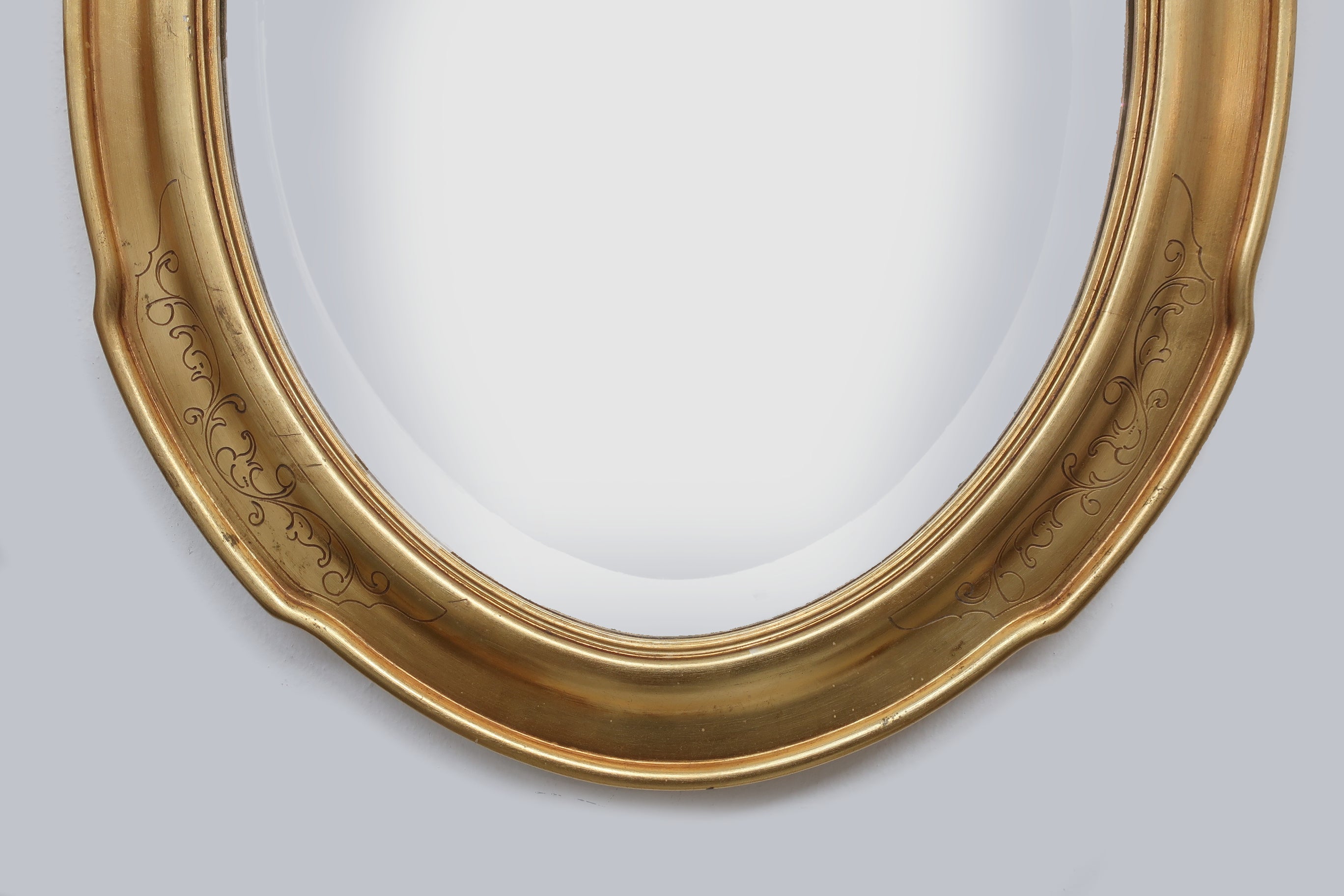 Specchiera ovale dorata con decori